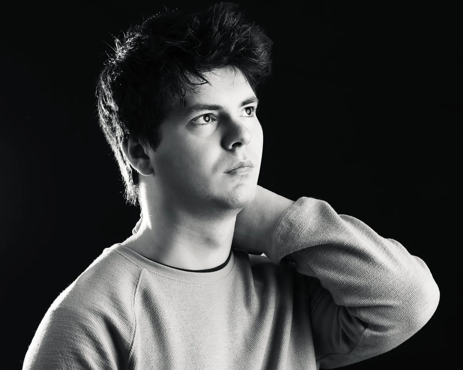 A black-and-white studio portrait of Nathan looking off to the side.